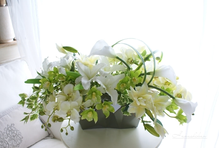 コチョウランとカラー、カサブランカを使ったエレガントな横長アレンジメント