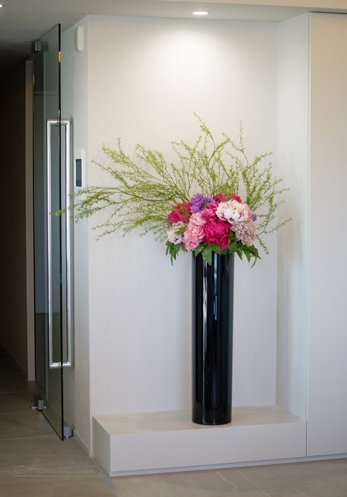 黒いシリンダーに映えるフューシャピンクのピオニーアレンジメント